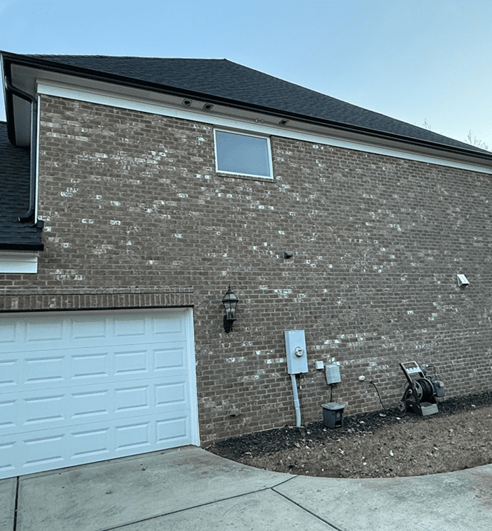 Brick house with garage and utility boxes.