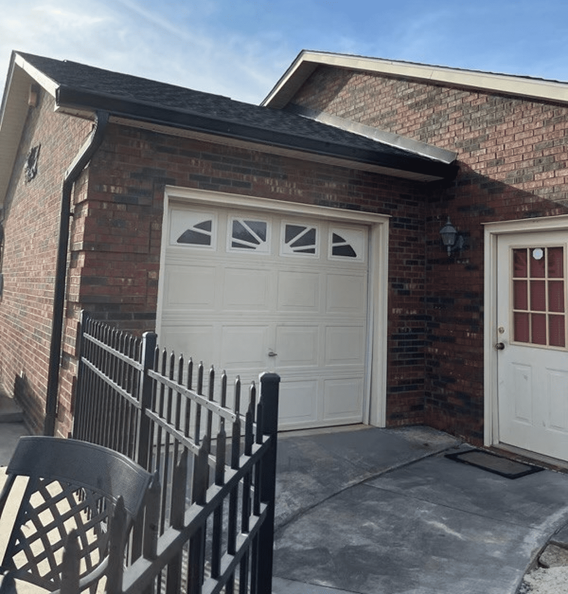 Brick house with white garage door.